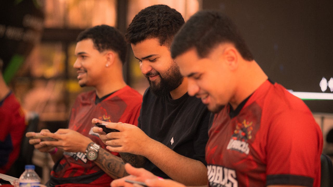 Group of young men focused on gaming with smartphones in an indoor setting.